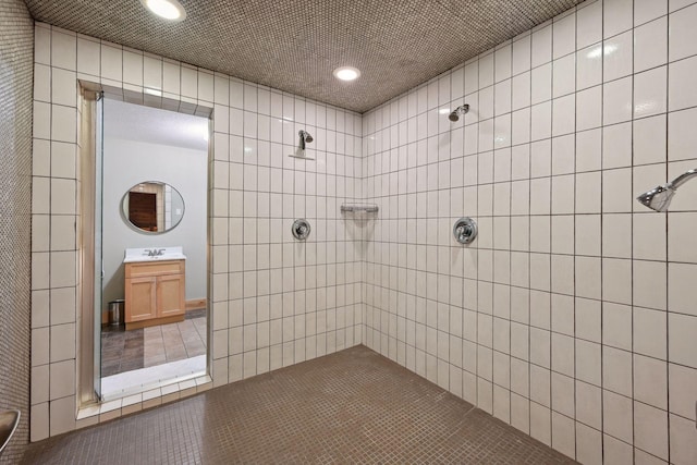 bathroom featuring recessed lighting, tile patterned floors, a tile shower, and vanity