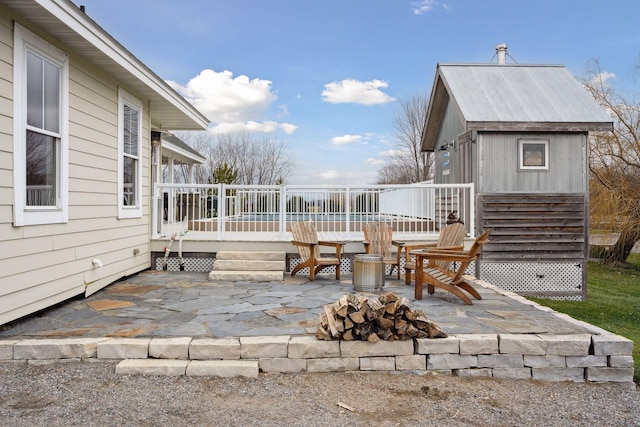 view of patio / terrace featuring a deck and a fire pit