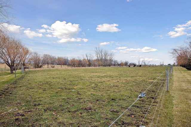view of yard featuring fence and a rural view