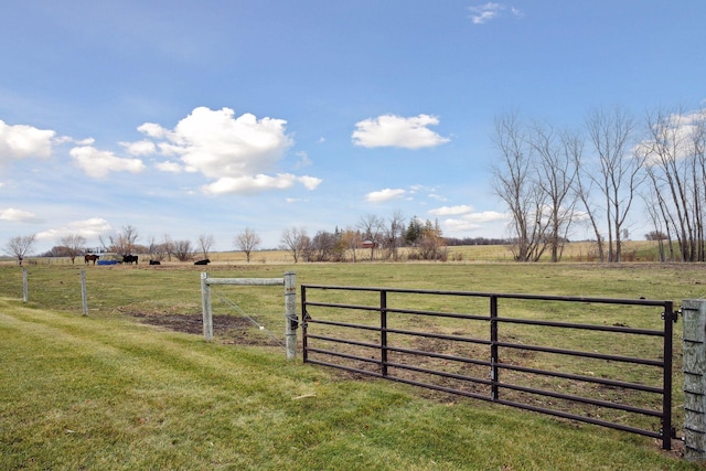 view of gate featuring a yard, a rural view, and fence