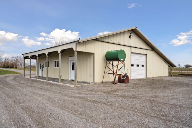 detached garage featuring fence and driveway