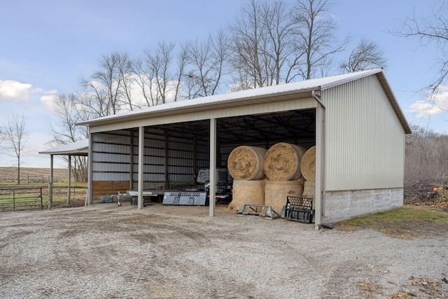 view of pole building with fence and a detached carport