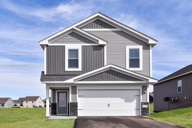 craftsman-style house with board and batten siding, a front lawn, stone siding, and a garage