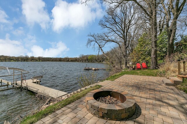 dock area featuring a water view, a patio area, and an outdoor fire pit