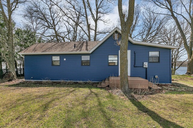 exterior space featuring a shingled roof and a yard