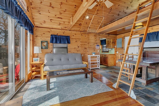 sitting room featuring wood finished floors, lofted ceiling, ceiling fan, wooden walls, and wood ceiling