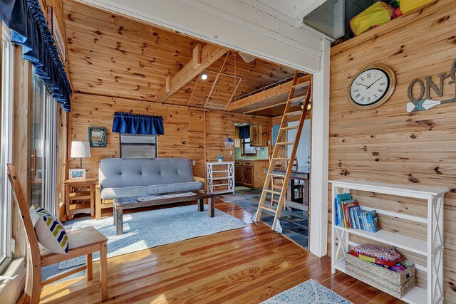 living area with wooden walls, wood ceiling, and wood finished floors