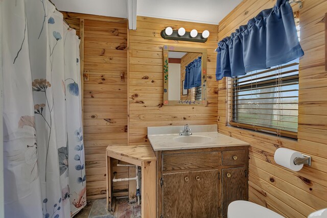 bathroom featuring wooden walls, toilet, curtained shower, and vanity