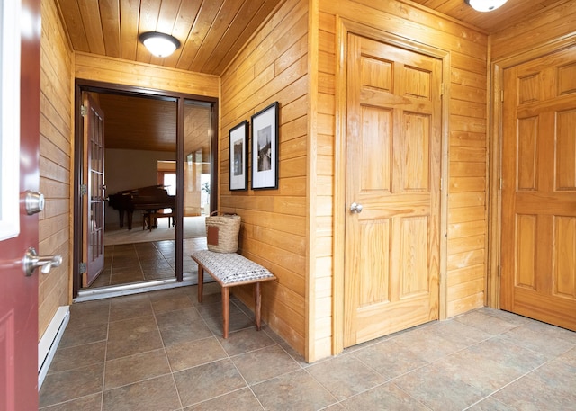 interior space with wooden walls, wood ceiling, and baseboard heating