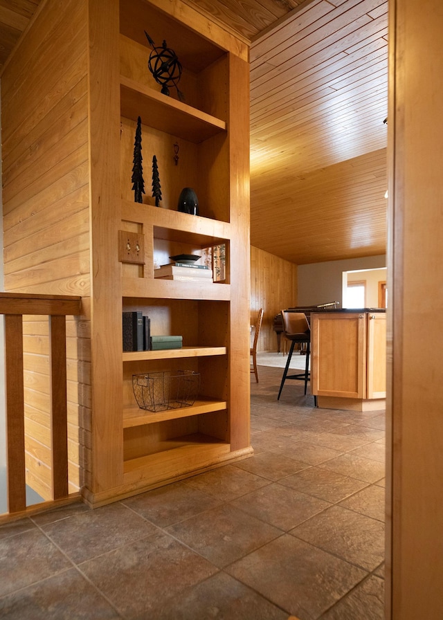 hall featuring wooden ceiling and wooden walls