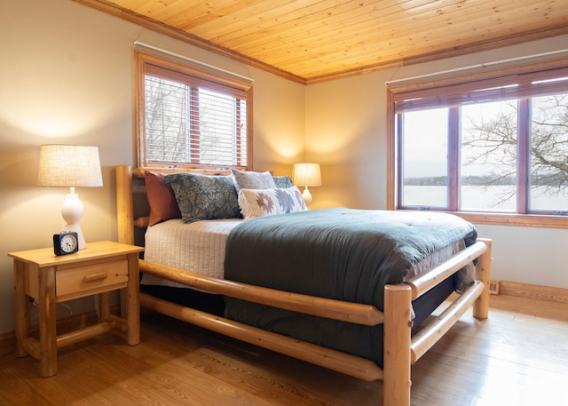 bedroom with wood finished floors, wooden ceiling, and ornamental molding