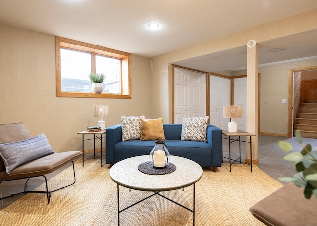tiled living room with baseboards and stairs