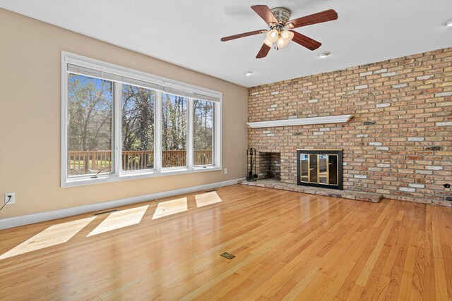 1337 Kenilworth Dr, Woodbury, MN 55125 - unfurnished living room with a ceiling fan, brick wall, a fireplace, wood finished floors, and baseboards