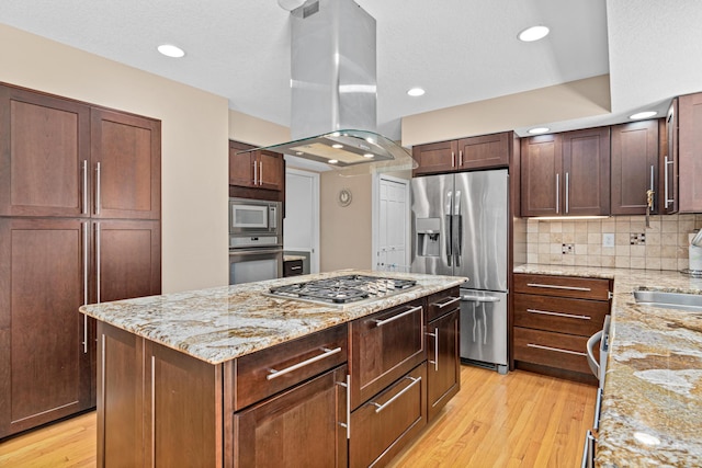 1337 Kenilworth Dr, Woodbury, MN 55125 - kitchen featuring light stone counters, appliances with stainless steel finishes, light wood-style floors, island range hood, and a kitchen island