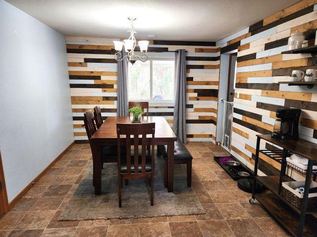 21 Main St, Luck, WI 54853 - dining room with a chandelier, stone finish flooring, and wood walls