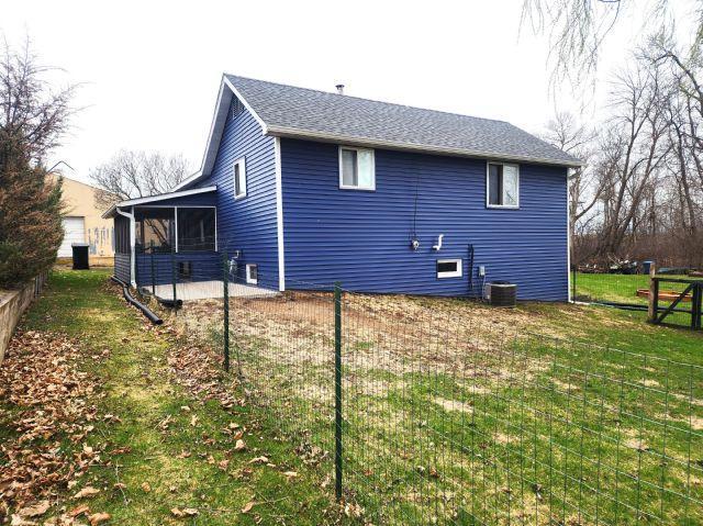 21 Main St, Luck, WI 54853 - back of house featuring a sunroom and a lawn