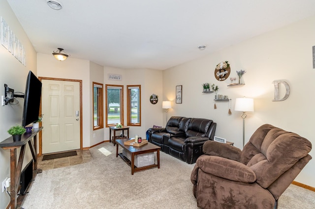 living area featuring baseboards, visible vents, and light colored carpet