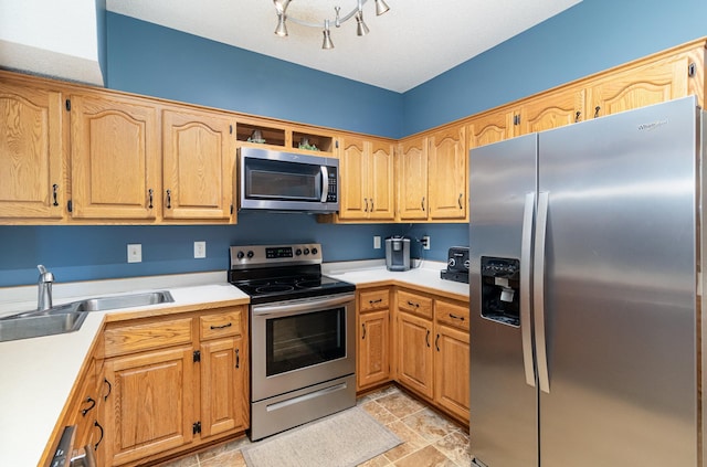 kitchen with light countertops, appliances with stainless steel finishes, and a sink