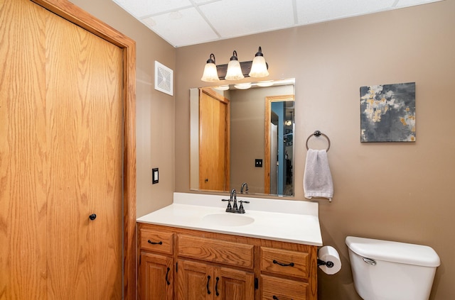 bathroom with visible vents, toilet, and vanity