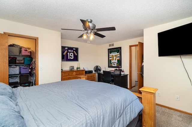 bedroom with a walk in closet, ceiling fan, light carpet, baseboards, and visible vents