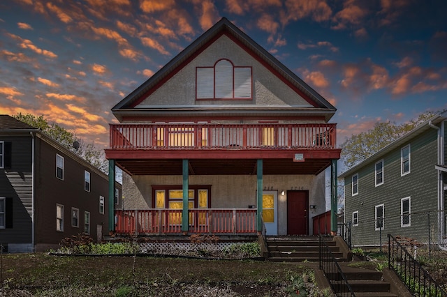 back of property with a porch and stucco siding