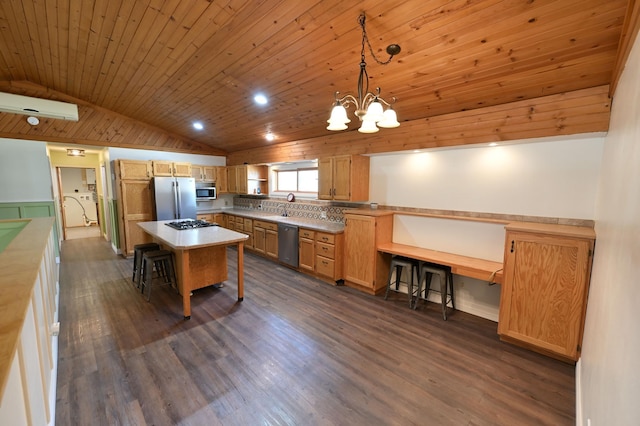 kitchen featuring dark wood finished floors, an inviting chandelier, a breakfast bar area, appliances with stainless steel finishes, and vaulted ceiling