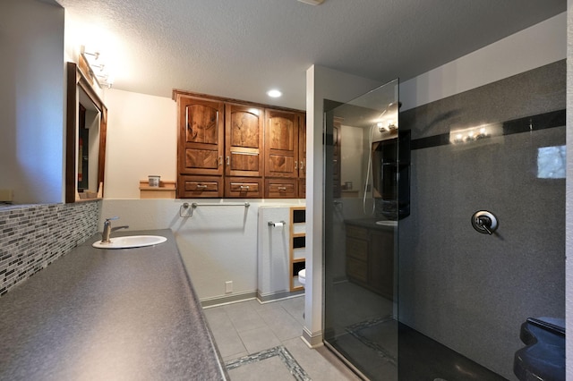 bathroom with toilet, a walk in shower, vanity, and tile patterned flooring