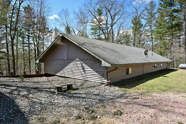view of property exterior with roof with shingles