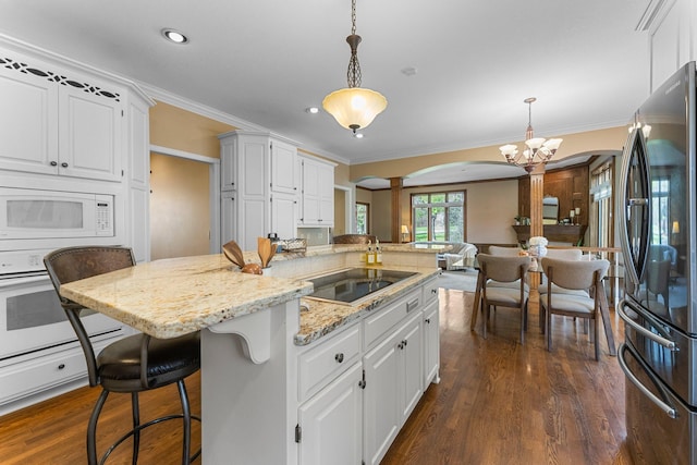 kitchen with ornate columns, dark wood-style flooring, white appliances, and arched walkways