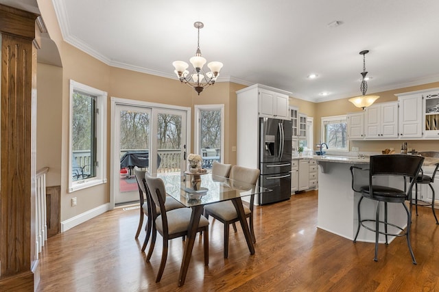 dining space with baseboards, ornamental molding, dark wood-style floors, and a chandelier