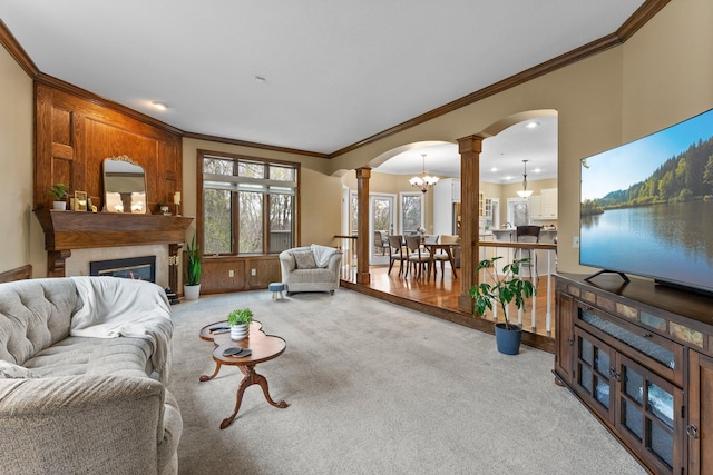 living area featuring arched walkways, a large fireplace, ornamental molding, carpet, and ornate columns