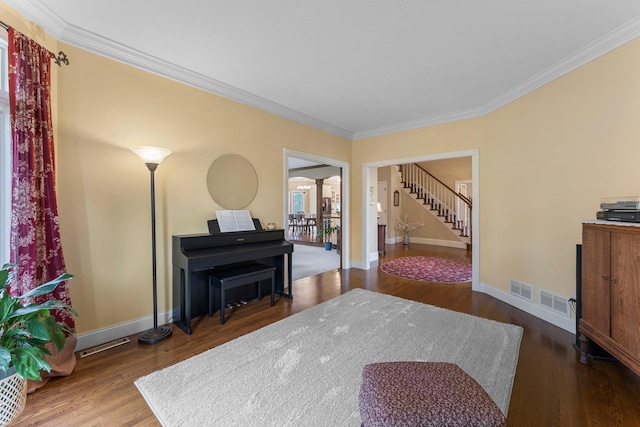sitting room with baseboards, ornamental molding, stairs, and wood finished floors