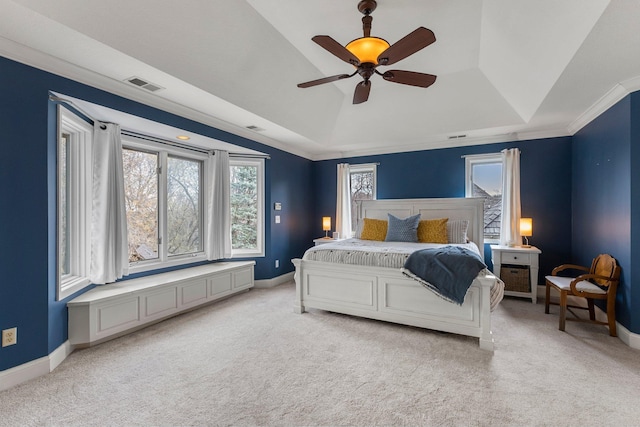 bedroom featuring baseboards, light carpet, a tray ceiling, and visible vents