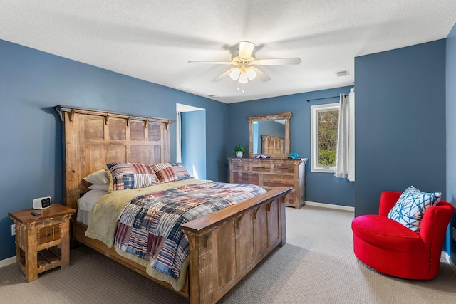 bedroom with a ceiling fan, a textured ceiling, visible vents, baseboards, and carpet
