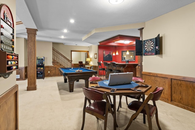 recreation room with carpet flooring, decorative columns, wainscoting, and indoor bar