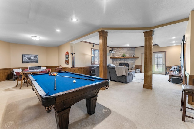 playroom featuring a fireplace, decorative columns, light carpet, and a wainscoted wall