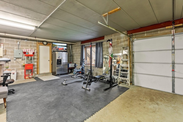 workout room featuring a garage and concrete block wall