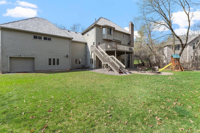 back of property featuring stairs, an outdoor fire pit, a garage, a deck, and a yard