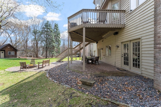 view of yard featuring a patio, a wooden deck, stairs, and an outdoor fire pit