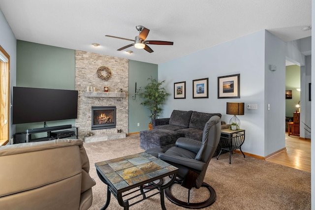 living area featuring a fireplace, baseboards, carpet, and ceiling fan