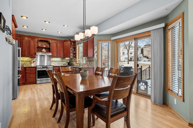 dining space featuring baseboards, recessed lighting, visible vents, an inviting chandelier, and light wood-style floors