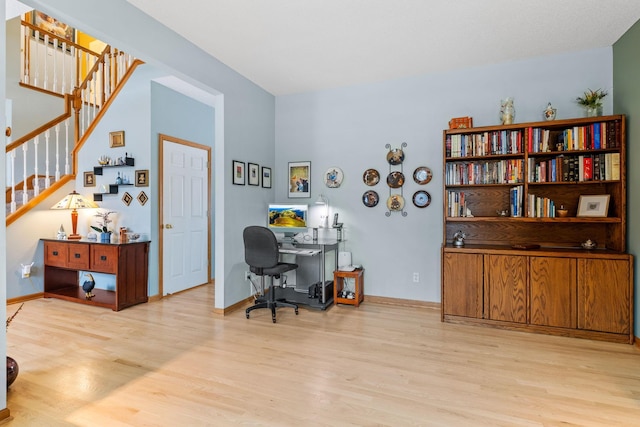 home office with light wood-type flooring and baseboards