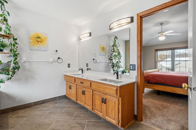 bathroom with double vanity, a ceiling fan, baseboards, and a sink