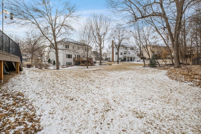 snowy yard featuring a residential view and a deck