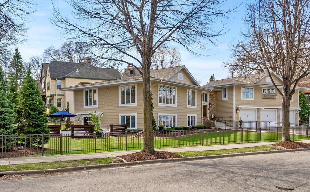 view of side of property featuring a lawn, a fenced front yard, driveway, and a garage