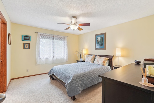 bedroom with carpet floors, baseboards, a ceiling fan, and a textured ceiling