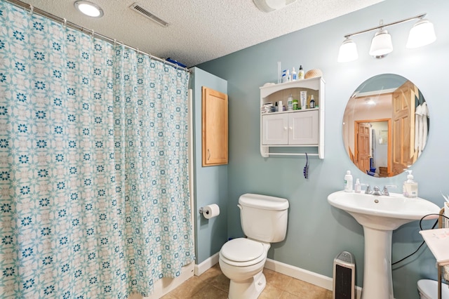 bathroom featuring toilet, a textured ceiling, tile patterned floors, curtained shower, and visible vents