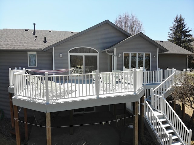 rear view of house with stairs, a shingled roof, and a wooden deck