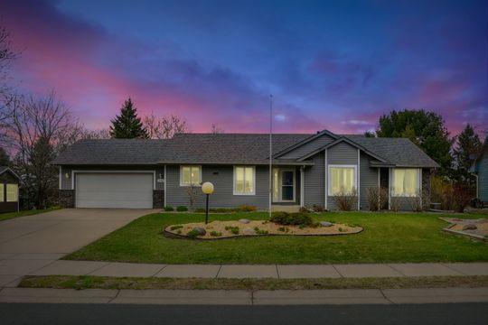 ranch-style home featuring a garage, concrete driveway, and a front yard