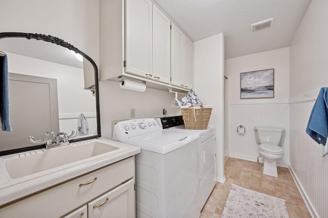 11 6th Ave S, Sartell, MN 56377 - washroom with washer and clothes dryer, a textured ceiling, stone finish floors, and wainscoting